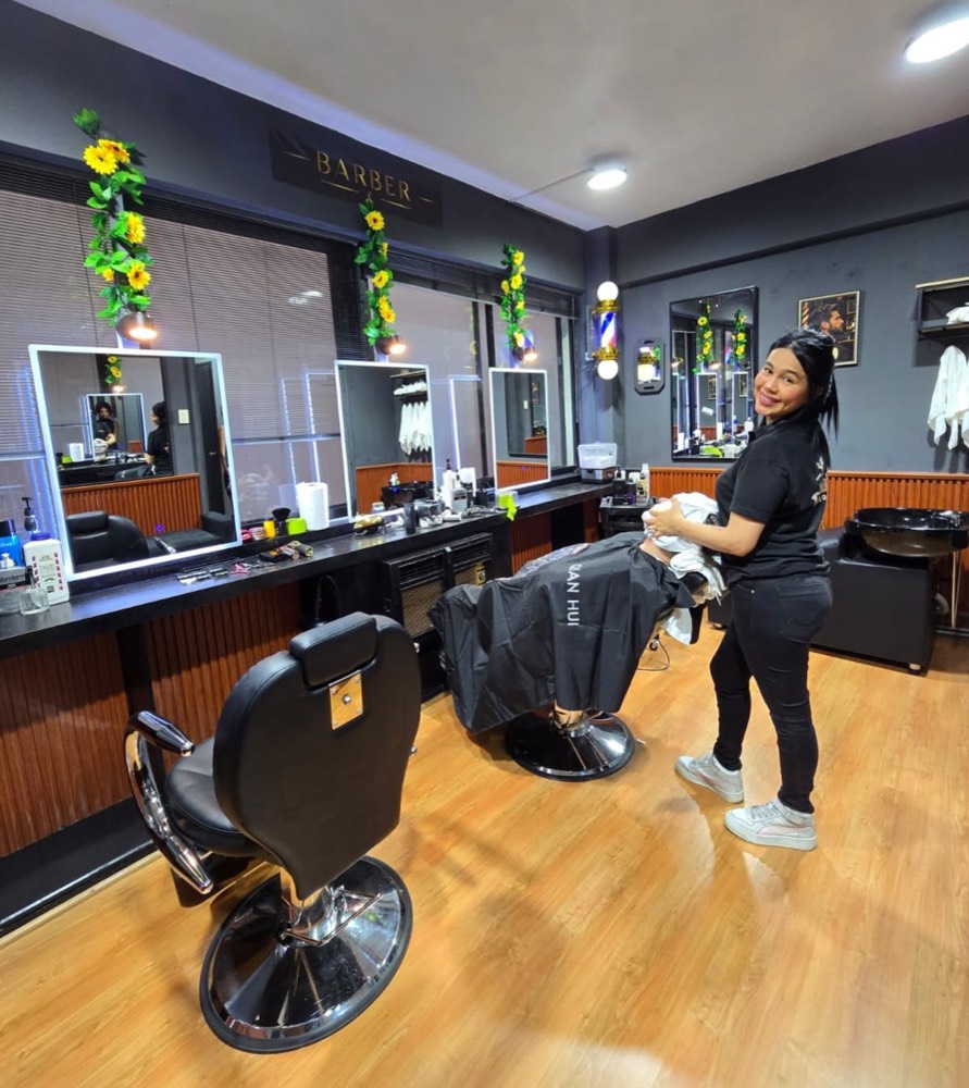 Interior de Barber Dueña's Studio con barbera atendiendo a un cliente